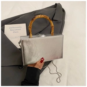 Close-up of silver box clutch bag with metallic texture and vintage bamboo top handle