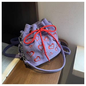 Detailed texture of purple corduroy bucket bag with red heart embroidery and drawstring