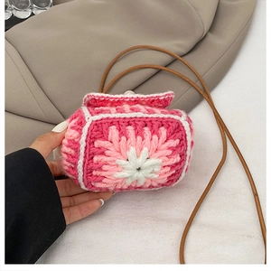 Detail of handmade floral knit mini bag featuring pink 3D petal texture and cord strap