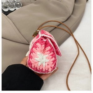 Macro detail of a pink floral handmade crochet mini crossbody knit bag for women