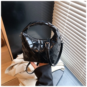 Détail du sac à bandoulière noir tressé avec double fermeture éclair et fini brillant
