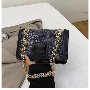 Close-up of retro crossbody bag with vintage embroidery patterns and gold chain