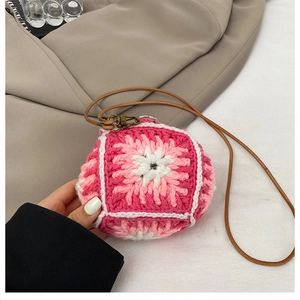Detail of handmade crochet sunflower mini bag with pink petals and brown leather strap