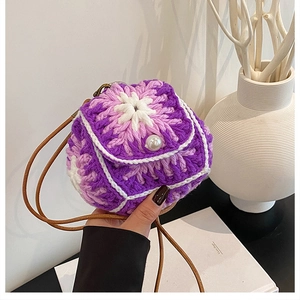 Detail of handmade crochet mini bag with white flower and pearl button closure