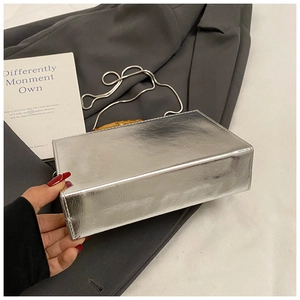 Detail of silver metallic box bag featuring bamboo handle and fine crinkled texture surface