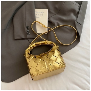 Vue rapprochée de la texture tissée dorée métallisée sur un sac à main élégant
