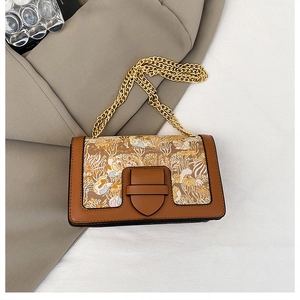 Detail view of retro vintage floral fabric bag with leather trim and gold chain strap