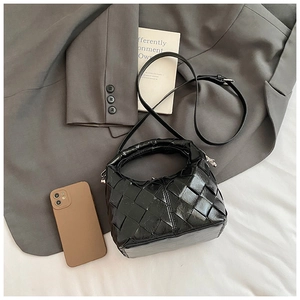 Détail du sac en cuir tressé brillant noir avec texture à larges mailles et poignée