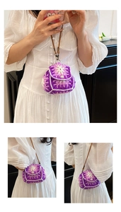 Close-up of a mini crochet knit bag with purple floral patterns and pearl buckle detail