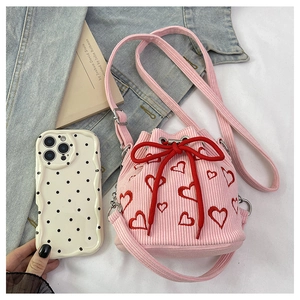 Top-down view of pink corduroy bucket bag with red heart embroidery and drawstring bow