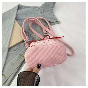 Close-up of pink corduroy bucket bag featuring embroidered heart and red drawstring