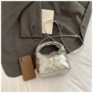 Détail du sac bandoulière argenté matelassé avec texture tissée et bandoulière réglable