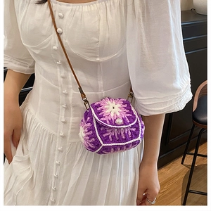 Detailed close-up of a purple floral crochet mini bag with elegant pearl clasp and strap