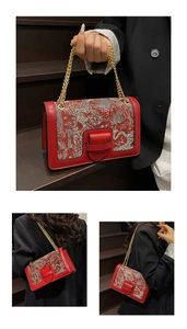 Detail of red leather bag with Chinese phoenix embroidery and gold chain strap