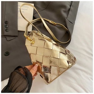 Détail du sac bandoulière tissé or champagne avec texture tressée complexe et sangle