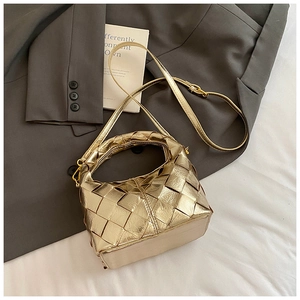 Détail du sac à main tissé or champagne avec texture métallique et garnitures dorées