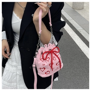 Detailed texture of pink corduroy bucket bag with red heart embroidery and drawstring