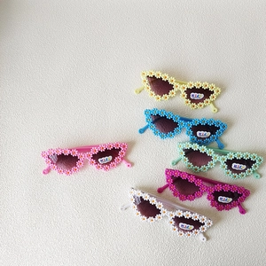 Set of 6 colorful flower-shaped kids sunglasses for girls and boys on beach vacation