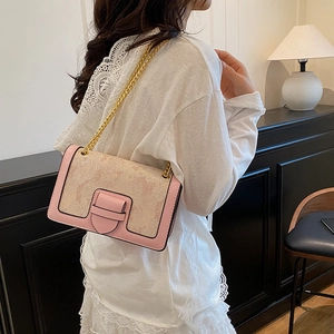 Pink and beige jacquard shoulder bag with chain strap shown on model in home setting