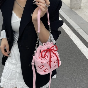 Pink corduroy bucket bag with red heart embroidery and drawstring bow detail