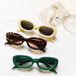 Lunettes de soleil rétro à petit cadre ovale en crème, écaille et vert foncé sur tissu
