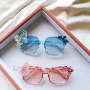 Détail de lunettes de soleil enfant avec nœud papillon et verres dégradés chic