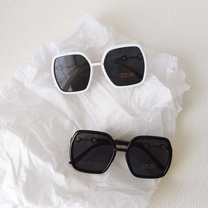 Lunettes de soleil enfant UV400 avec détail mors doré en montures noires et blanches