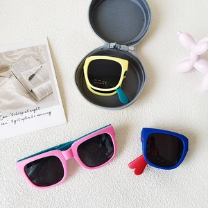 Foldable kids UV400 sunglasses in various color blocks with a round zipper storage case