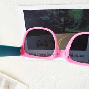 Foldable polarized kids sunglasses in pink and blue frame showing testing card
