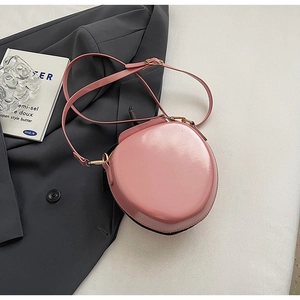 Detailed close-up of pink glossy PU leather crossbody bag with golden metal hardware