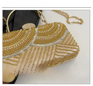 Detailed view of the gold sequins, white pearls and metallic beads on the evening bag