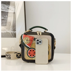 Detail of cartoon bear square bag with watermelon pendant and wide woven strap