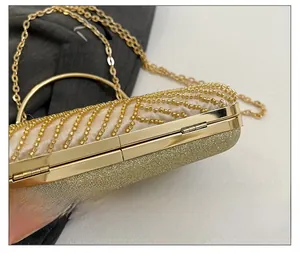 Detail showing wave-patterned gold beads, metal frame, and top handle of the evening clutch