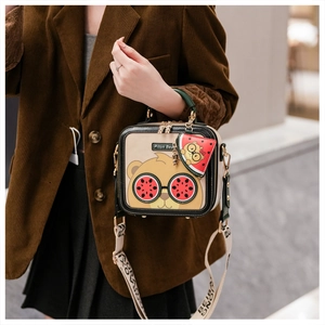 Detail of cartoon bear crossbody bag with watermelon charm and beige shoulder strap