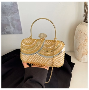 Detail of luxury evening clutch bag with sequins, pearls, and a gold metal circular handle