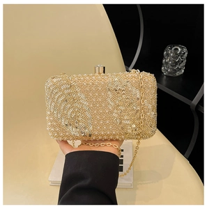 Close-up of golden sequin evening clutch with pearl texture and crystal clasp