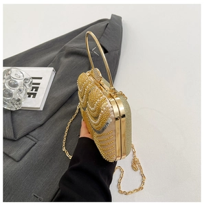 Close-up of golden sequins and pearls on party clutch bag with round handle