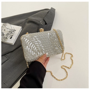 Detail of silver sequin evening bag with leaf patterns and crystal clasp closure