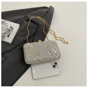 Detailed silver sequin clutch bag with leaf texture, gold chain and spherical clasp