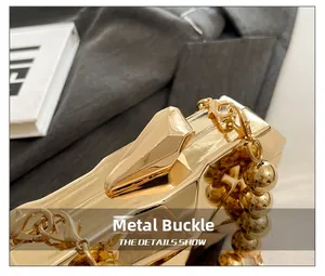 Detail of the golden metal evening bag showing the geometric shell and sturdy hardware clasp