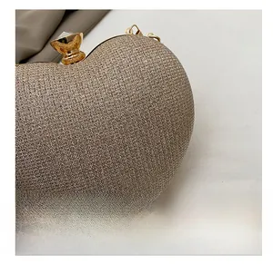 Detail of champagne glitter heart clutch bag with crystal-embellished gold clasp