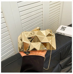 Macro shot of geometric gold metallic evening clutch with 3D faceted texture and chain