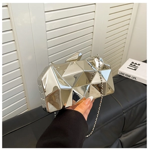 Detail of silver geometric hardshell evening bag with diamond-cut facets and chain strap
