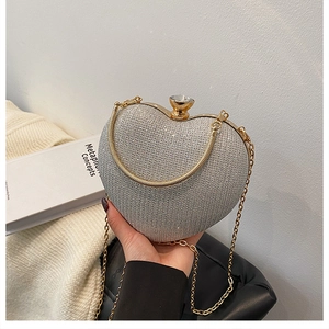 Detail of silver heart-shaped evening bag with sparkling sequins and gold metal frame