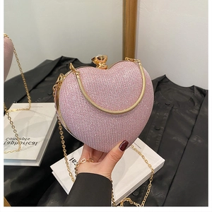 Detail of pink heart-shaped sequin evening bag with gold chain and diamond buckle