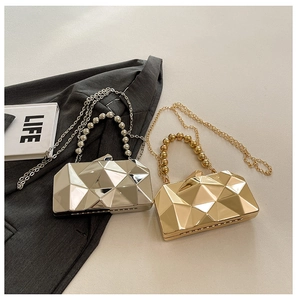 Detail of 3D geometric evening bag with pearl handle and sleek metallic facets