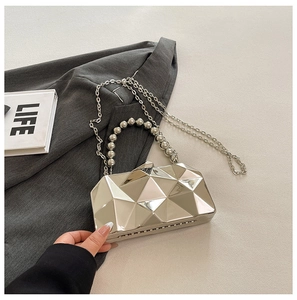 Macro shot of silver geometric metallic evening bag with faceted mirror finish design