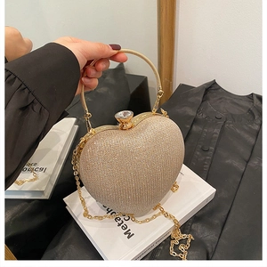 Macro detail of champagne heart glitter evening bag with jewel clasp and metal handle