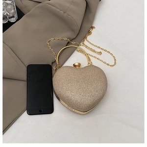 Detailed view of heart-shaped glitter clutch bag with metal chain and top handle ring