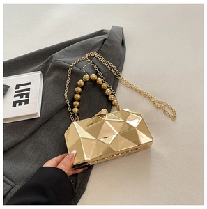 Detail of a gold geometric metallic evening bag with beaded handle and fine chain strap